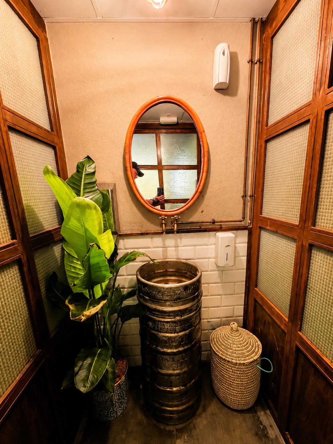Rustic washroom detail with plants and a barrel sink at THAI ISAAN